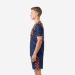 Rear side view of navy and athletic orange sublimated soccer uniform showing checkerboard shorts panel and jersey cut
