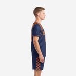 Side view of custom orange and navy blue checkerboard soccer uniform showing sleeve trim and shorts side panel design