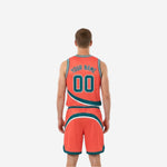 Side view of the orange and teal reverse side of the basketball uniform showing the coral-orange jersey with teal diagonal stripe and matching orange shorts