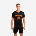 Front view of orange soccer training jersey in jet black with orange diagonal stripe panels and V-neck collar trim