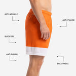 Athletic fit orange and white custom mens soccer shorts full length view on adult male model