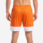 Hem contrast panel detail on orange and white custom mens soccer shorts showing colorblock boundary stitching