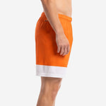 Side view of orange and white custom mens soccer shorts showing wide white contrast hem panel and elastic waistband