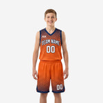 Orange youth basketball uniforms two-piece set with navy halftone dot pattern, bold white arced team name and front and back numbers on youth boy model