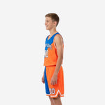 Side view of orange youth basketball uniforms showing diagonal split panel on jersey and matching color-block shorts with white hem trim
