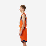 Side view of orange and navy youth basketball uniform showing navy armhole binding, side panel, and shorts leg piping detail