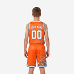 Back view of orange youth basketball uniforms showing sublimated player name and back number on jersey and matching orange shorts with chevron hem