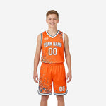 Orange youth basketball uniforms with gray splash pattern, youth boy wearing matching V-neck jersey and shorts with team name and number 00 sublimated on front
