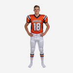 Custom orange youth football uniforms front view showing navy V-neck collar, team name arc, front number 18, and matching white pants with navy-orange side stripe
