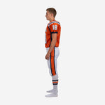 Left side view of sublimated orange youth football uniform with navy sleeve trim and white pants featuring navy-orange leg stripe