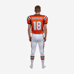 Right side view of custom orange youth American football uniform showing set-in sleeve cut and white pants with orange panel detail at knee