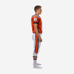 Orange and navy youth football uniform side view showing navy side panel on jersey and full-length orange stripe on white football pants