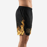 Black custom basketball shorts with full-sublimation gold and amber flame graphic on the left leg panel and bold gold player number on the right thigh