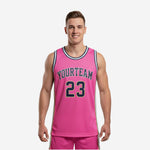 Custom pink basketball jersey designs with navy arched team name, front number 23, white side panels, and multi-stripe crew neck trim on adult male model - front and back view