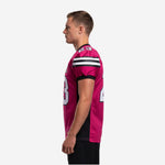 Side view of pink and black custom mens football jersey showing set-in sleeve, black cuff band, and vertical black side panel