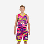 Custom pink youth basketball uniforms in pink and purple camo with neon yellow trim showing front and back of full set