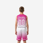 Opposite side view of youth pink basketball jersey and shorts set showing armhole binding and shorts side-split triangle detail