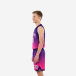 Side view of pink youth basketball uniforms showing continuous purple-to-pink gradient wrapping jersey and shorts panels