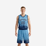 Carolina blue basketball uniforms with navy pixel-burst gradient hem, full set front and back view showing team name and number sublimation