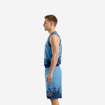 Side view of carolina blue and navy sublimated basketball uniform set showing pixel-burst hem pattern on jersey and shorts