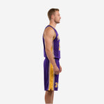 Side view of purple and gold basketball uniform set showing continuous gold side panel running from jersey underarm through matching shorts hem