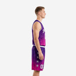 Side view of purple and pink sublimated basketball uniform showing V-neck binding, star motif on shorts panels, and gradient fade from purple to pink