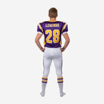 Right side view of custom youth American football uniform in purple and gold showing set-in sleeve cut and full-length pant stripe detail