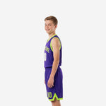 Side view of purple and neon lime youth basketball uniform set showing sleeveless jersey fit and matching shorts with V-notch lime hem trim detail