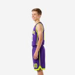 Youth sublimated basketball uniforms side view showing lime green side panel trim stripe on jersey and matching shorts hem detail