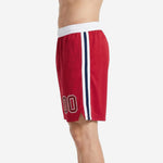 Second side view of red sublimated basketball shorts with white drawcord waistband and navy stripe detail on the leg panel