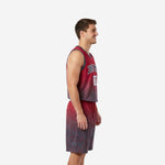 Side view of custom red and black basketball uniform showing charcoal armhole binding, gradient fade from crimson to charcoal, and matching shorts