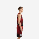 Custom red and black basketball uniform front view showing crimson red base with black ink-burst graphic fading from hem and white player number centered on the jersey chest