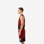 Side view of red and black sublimated basketball jersey and shorts showing black armhole binding, athletic cut jersey hem, and splash pattern on the lower shorts leg