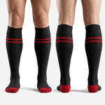 Full-length view of sublimated red and black team soccer socks on male player, showing stripe and cuff