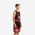 Side view of red and black youth basketball uniform set showing flame graphic wrapping jersey sides and shorts lower panels