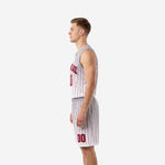 Side view of red and white custom basketball uniform set showing jersey hem, waistband, and shorts leg length