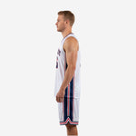 Side view of custom red and white basketball uniform showing navy side panel stripe on jersey and shorts
