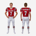 Back view of red and white youth football uniform displaying back number nameplate and sublimated red black pant side stripe