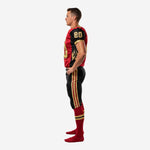 Left side view of custom red and black football uniform showing black side panel, gold sleeve cuff trim, and full-length black pants with triple stripe detail