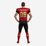 Right side view of red and black football uniform showing sublimated flame graphic on jersey side panel and matching black pants leg stripe pattern