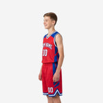 Close side view of red youth basketball uniform highlighting royal blue geometric panel design on jersey side and shorts with white armhole binding detail