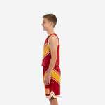 Left side view of red and gold youth basketball uniform showing diagonal gold panel alignment on jersey and shorts