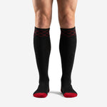 Front view of custom red and black soccer socks with red diamond trim cuff and red toe block on male model