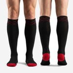 Full-length profile of custom red and black soccer socks on male model showing athletic over-the-calf fit
