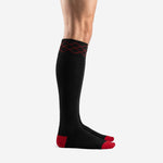 Left side view of custom red and black soccer socks showing full over-the-calf length and red geometric cuff trim