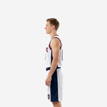 Side view of red white and blue basketball uniform showing navy side panel tapering from armhole to hem on jersey and full-length navy panel on shorts