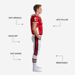 Close detail of red and white sublimated youth football uniform showing V-neck trim binding, shoulder panel stripe, and arched team name print zone