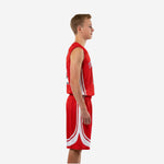 Front view of custom red youth basketball uniform set with white curved side panels on jersey, arched TEAMNAME lettering in white with black outline, and number 12 on chest and shorts leg