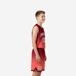 Side view of youth boy wearing red and maroon sublimated basketball uniform set showing V-neck jersey and gradient shorts