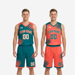 Close-up detail of teal and orange basketball shorts showing diagonal slash sublimation on outer thigh and orange hem binding